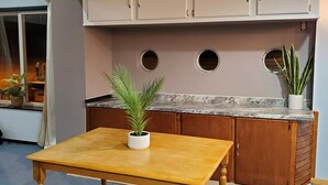 Una cocina con armarios de madera, encimera de mármol y una mesa con una planta en maceta.