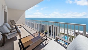 A balcony with a view of the ocean and a pool area. - Crystal Tower 1907 (Gulf Shores)