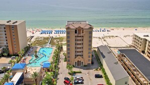 Un hôtel doté d’une piscine, d’un accès à la plage et de plusieurs balcons.