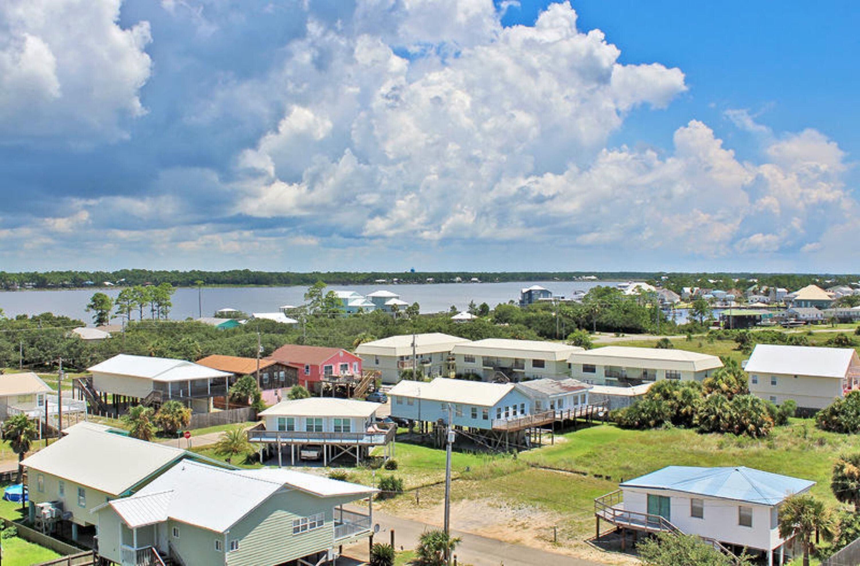 A coastal residential area with houses, a dock, and a view of the water.