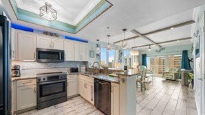 Una cocina moderna con armarios blancos, electrodomésticos de acero inoxidable y una isla grande.