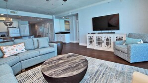 A living room with a sofa, a coffee table, and a television. - San Carlos 409 (Gulf Shores)