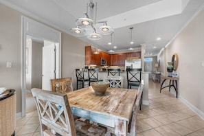A modern kitchen with wooden cabinets, a central island, and pendant lighting. - The Wharf 521 by Youngs Suncoast (Orange Beach)