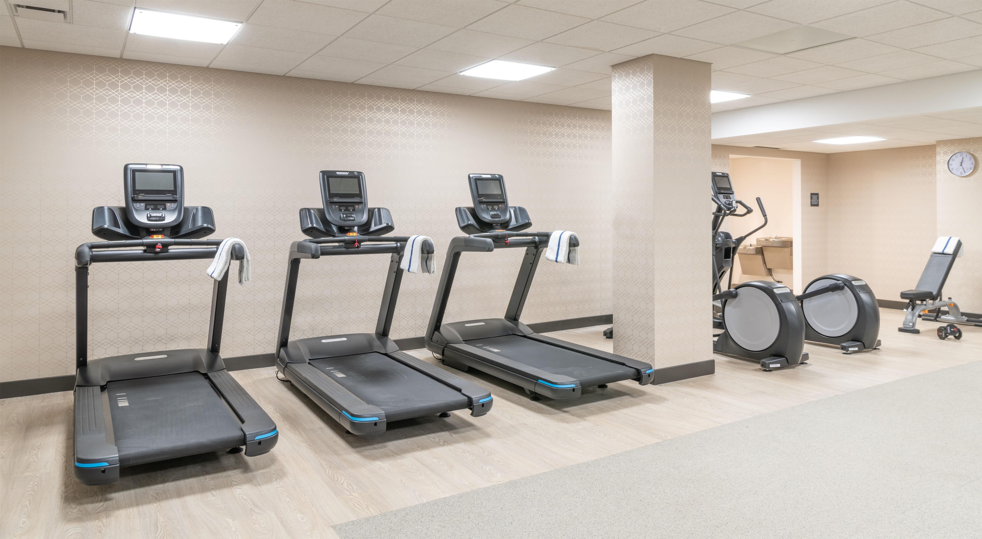A fitness center with treadmills, a stationary bike, and a rowing machine.