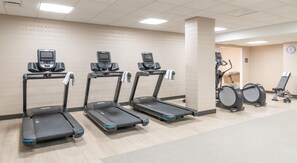 Un centre de remise en forme équipé de tapis de course, d’un vélo d’appartement et d’un appareil d’aviron.