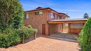 A two-story brick house with a covered driveway and a gated entrance. - Duplex with views in a quiet area (Nelson Bay)