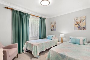 A bedroom with two beds, a window with curtains, a painting on the wall, and a lamp on a bedside table. - Wahgunyah Family Friendly in Nelson Bay (Nelson Bay)