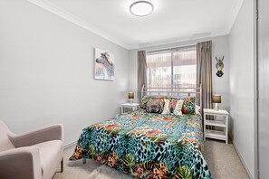 A bedroom with a zebra-themed bedspread, a zebra painting on the wall, and a zebra head decoration. - Wahgunyah Family Friendly in Nelson Bay (Nelson Bay)
