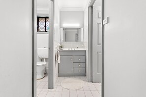 A bathroom with a toilet, sink, mirror, and a small window. - Wahgunyah Family Friendly in Nelson Bay (Nelson Bay)
