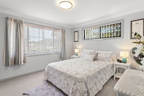 A bedroom with a large bed, two bedside tables with lamps, a window with curtains, and a wall-mounted picture. - Wahgunyah Family Friendly in Nelson Bay (Nelson Bay)