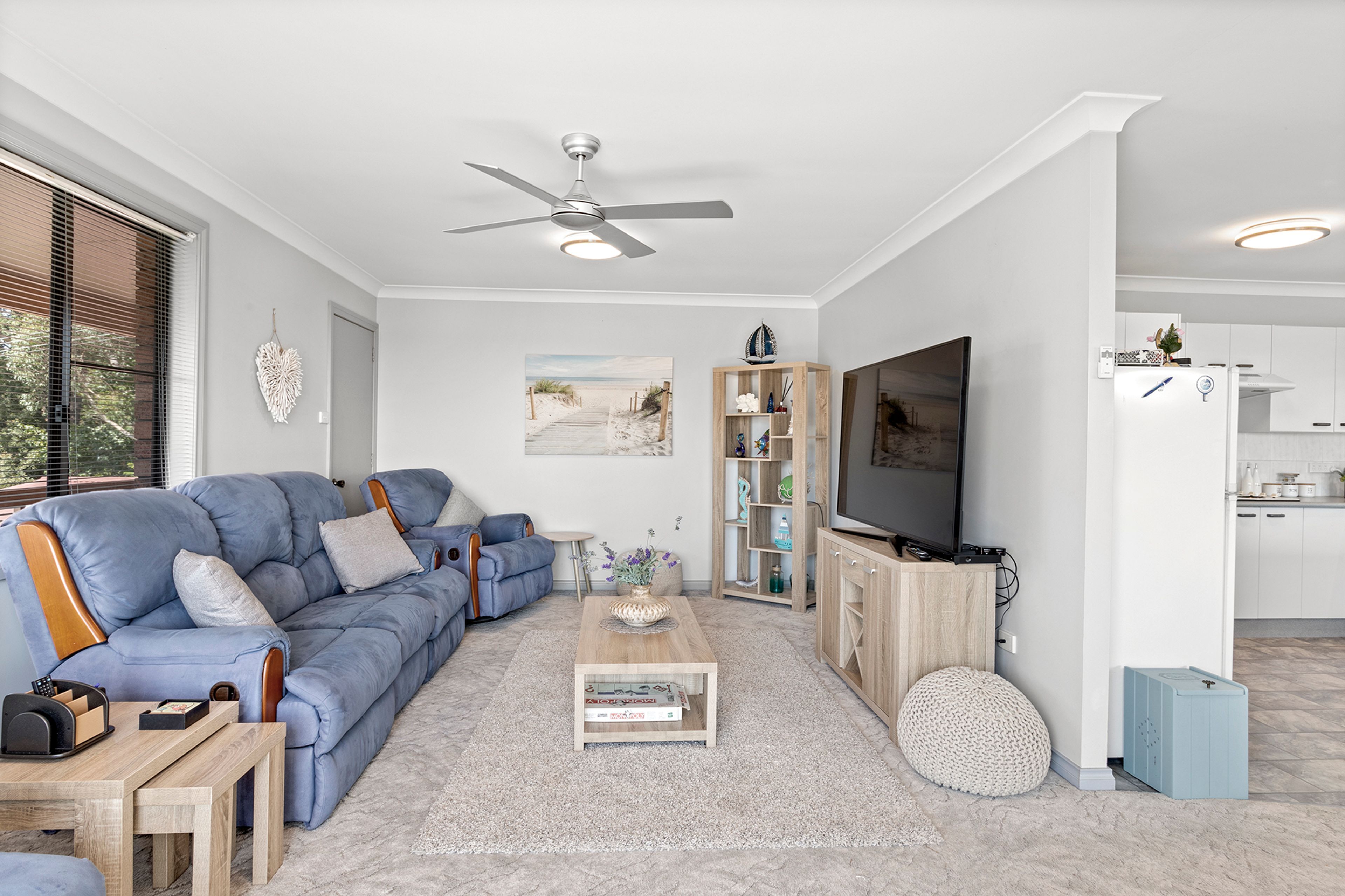 A modern living room with a blue sofa, a coffee table, and a television.