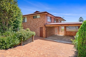 A two-story brick house with a covered driveway and a gated entrance. - Wahgunyah Family Friendly in Nelson Bay (Nelson Bay)