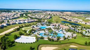 Un complexe hôtelier proposant un parcours de golf, plusieurs piscines, des pelouses bien entretenues et différents bâtiments.