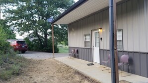 Un motel doté d’un porche abrité, d’une voiture garée devant et d’une allée gravillonnée.