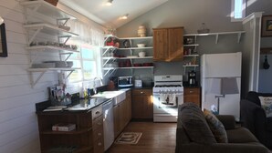 A compact kitchen with wooden cabinets, a stove, and a refrigerator. - Our Cozy, Quiet, Comfortable place in the Country - 2 Bedroom 900 sq ft w/view (Lockhart)