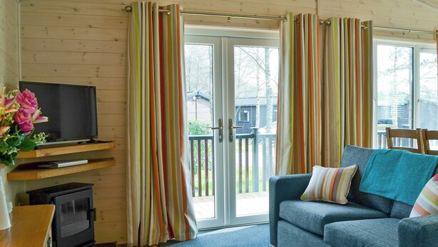 A cozy living room with a television, sofa, and curtains. - 2 bedroom accommodation in Burnside Park (Burnside Park)