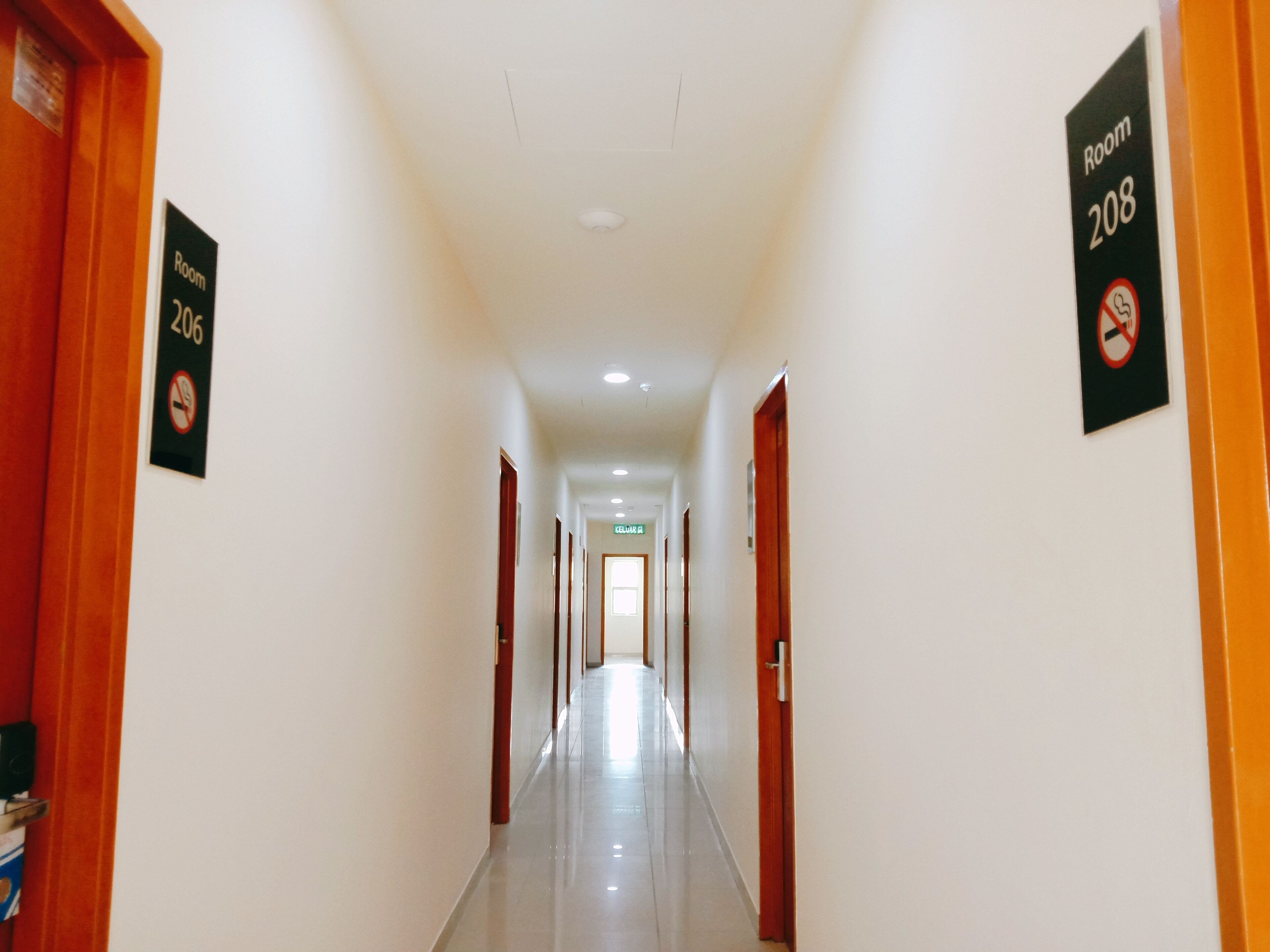 A hotel hallway with signs indicating Room 206 and Room 208.