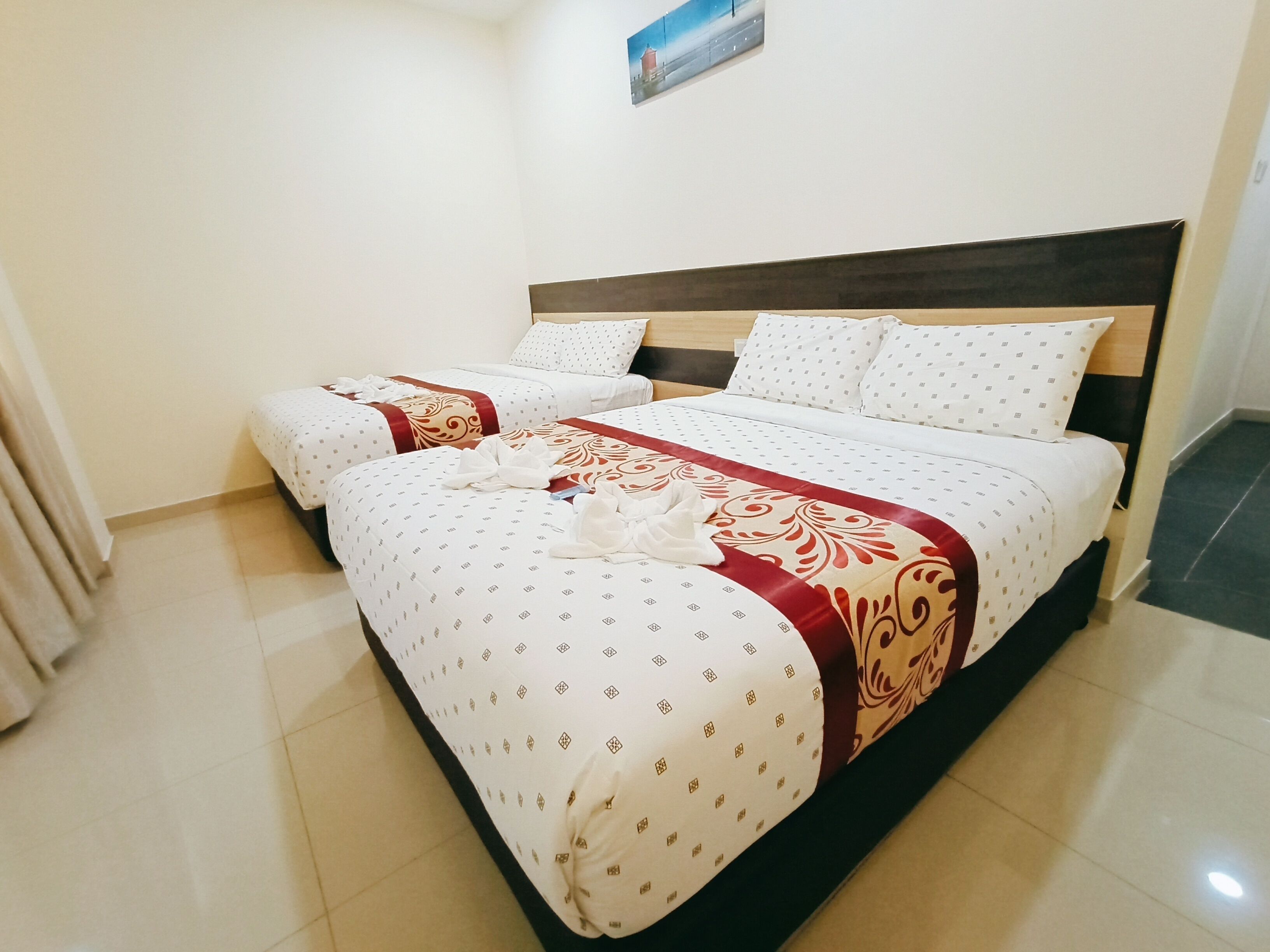 A hotel room with two beds, a wooden headboard, and a tiled floor.