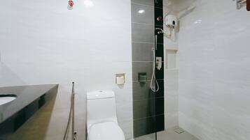 Un bagno moderno con il water, una doccia e un lavandino.