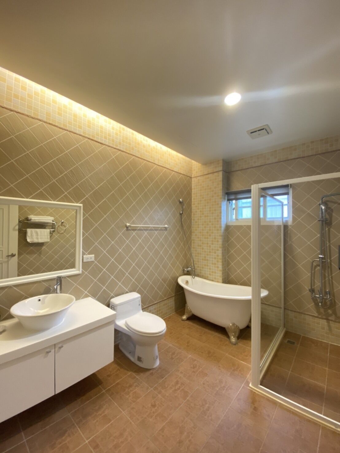 Un baño con lavamanos, inodoro, bañera y cabina de ducha con mampara de vidrio.