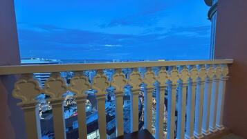 A balcony with a view of a cityscape at dusk.