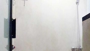 A small bathroom with a toilet, a shower, and a glass door. - D'Paragon Beo (Depok)