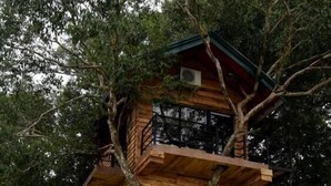 A multi-story wooden cabin with balconies, surrounded by trees. - The Lion Kingdom Sigiriya (Dambulla)