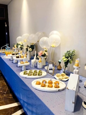 Una mesa de buffet con diversos alimentos y decoraciones.