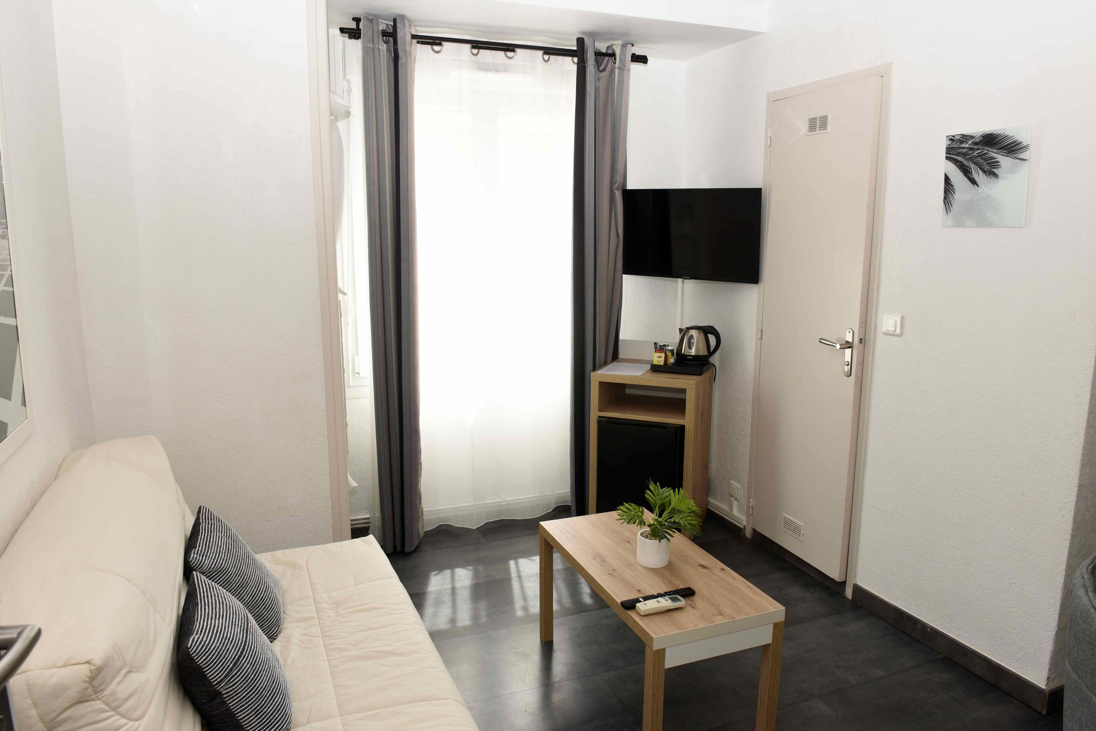 basic quadruple room, multiple beds, non smoking | living area | flat-screen tv