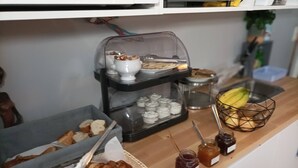 A breakfast buffet with croissants, bread, pastries, and jams. - Azur Hotel (Balaruc-les-Bains)