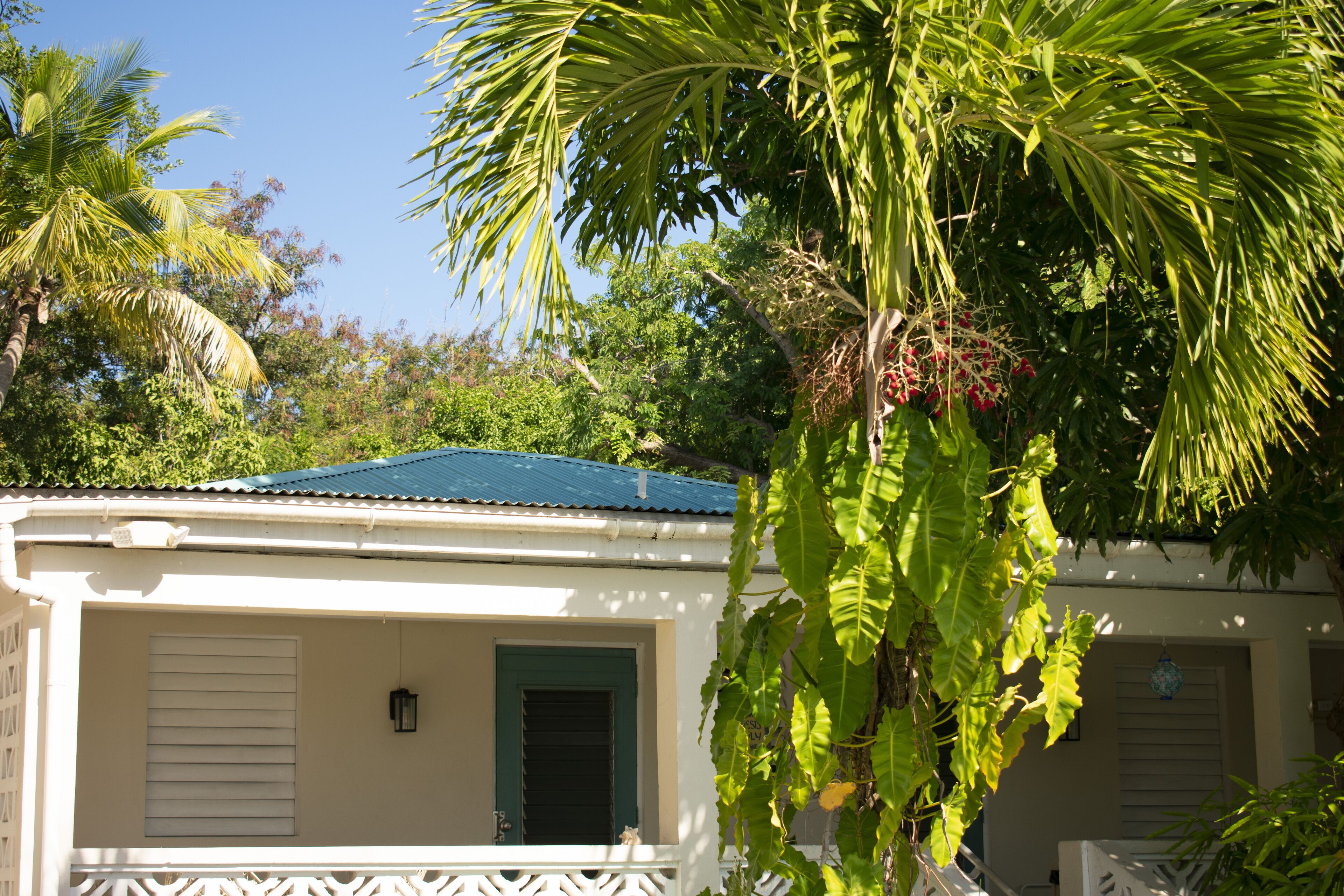 A house with a green door, white shutters, and a balcony with a white railing.