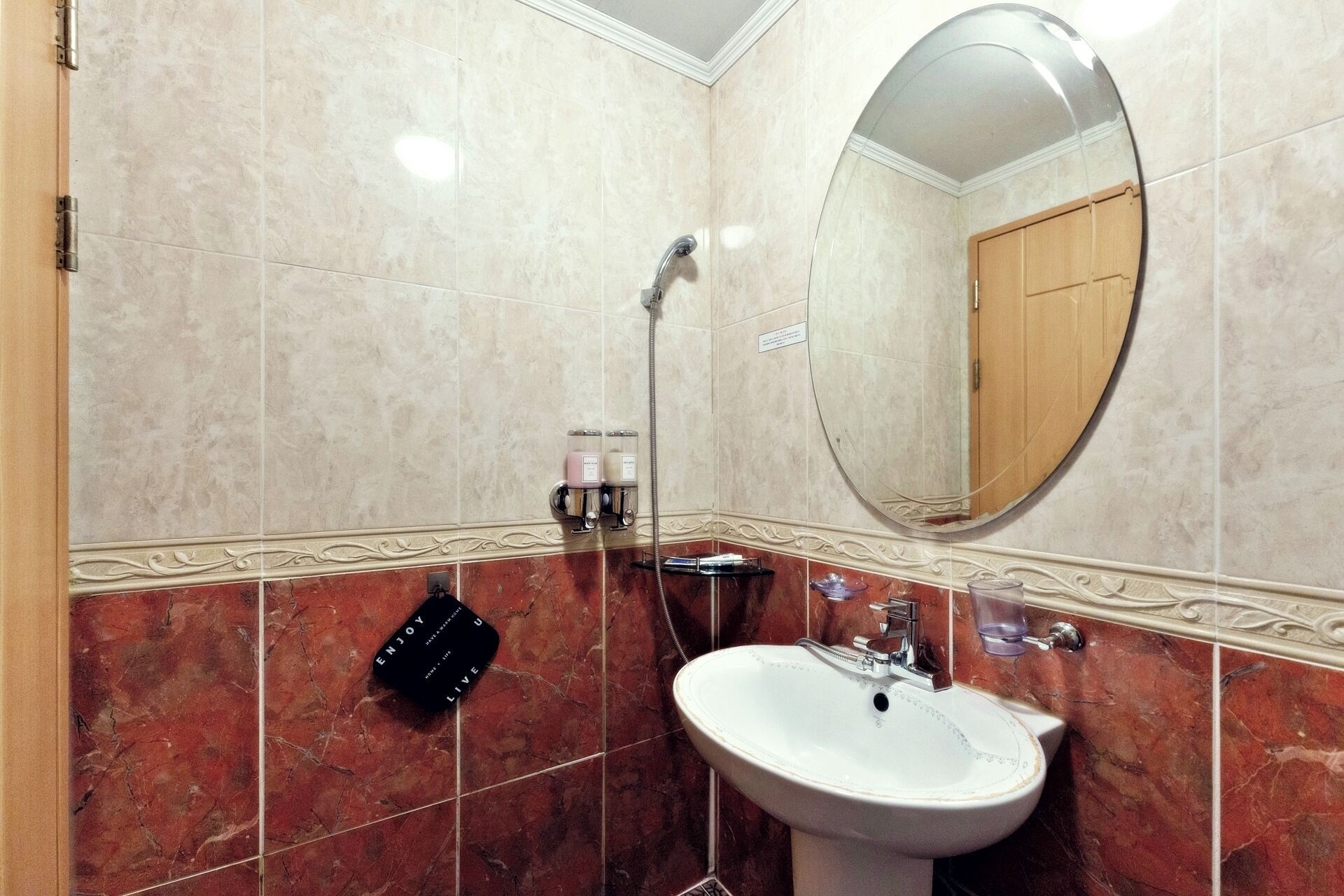 Un baño con lavamanos blanco, un espejo y una ducha.