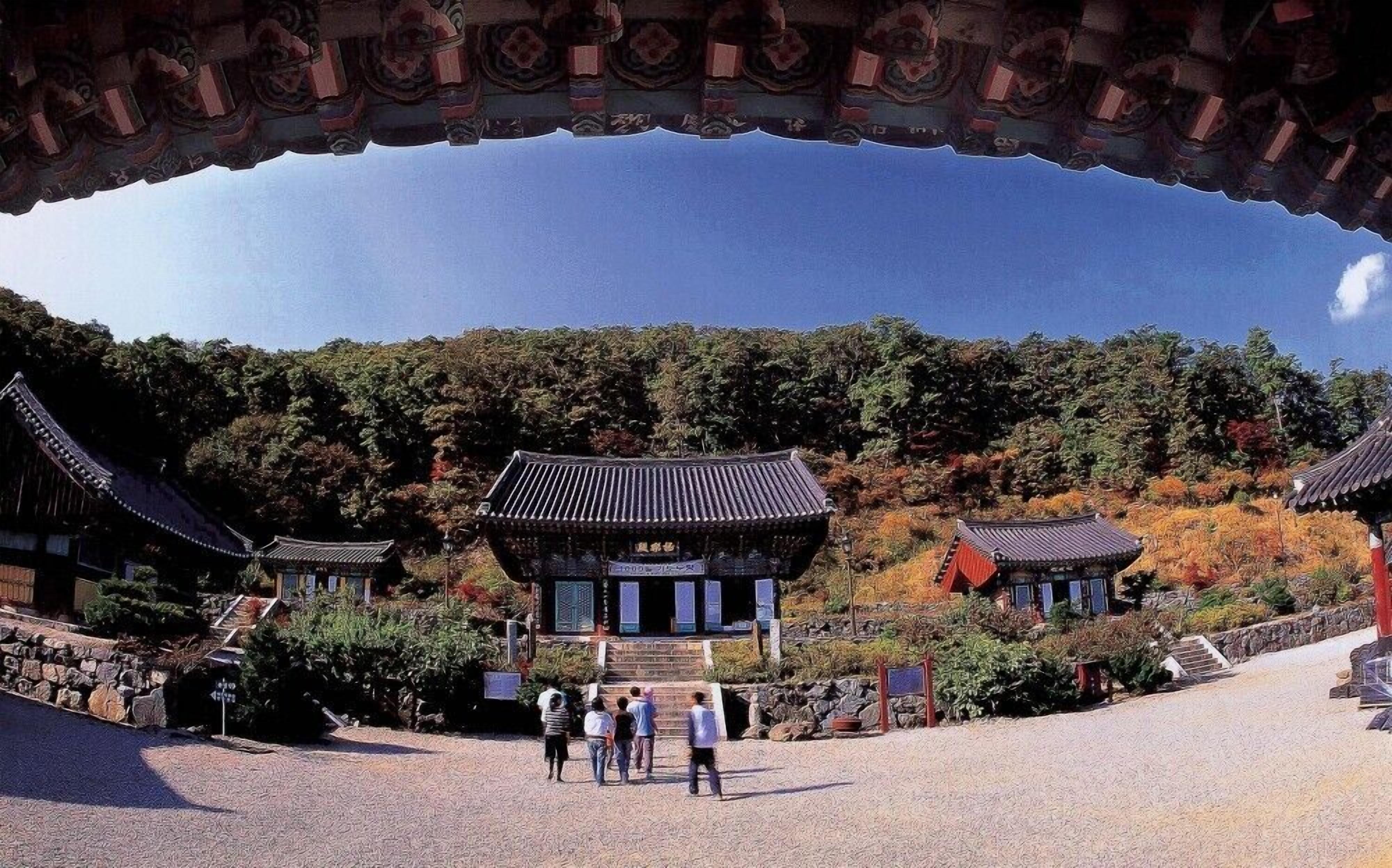 Een traditioneel Japans tempelcomplex met meerdere gebouwen, een pad van stenen en bezoekers.