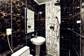 A bathroom with a toilet, sink, and shower. The walls have a black and gold marble pattern. - Muju Cherish Pension (Muju)