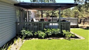 Une maison dotée d’un porche abrité, d’une terrasse clôturée et d’une pelouse bien entretenue.