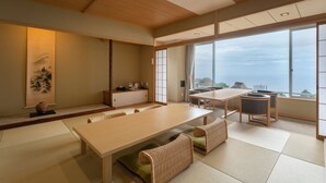 A traditional Japanese-style room with tatami flooring, a low table, and a view of the sea. - Ishinoya Atami (TKP Hotels & Resorts) (Atami)