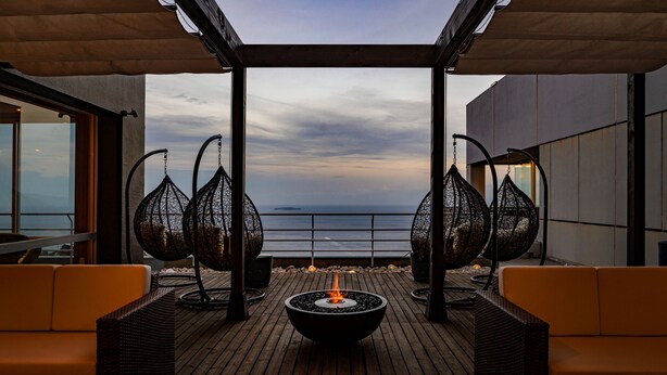 A wooden deck with a fire pit, wicker chairs, and a view of the ocean. - Ishinoya Atami (TKP Hotels & Resorts) (Atami)