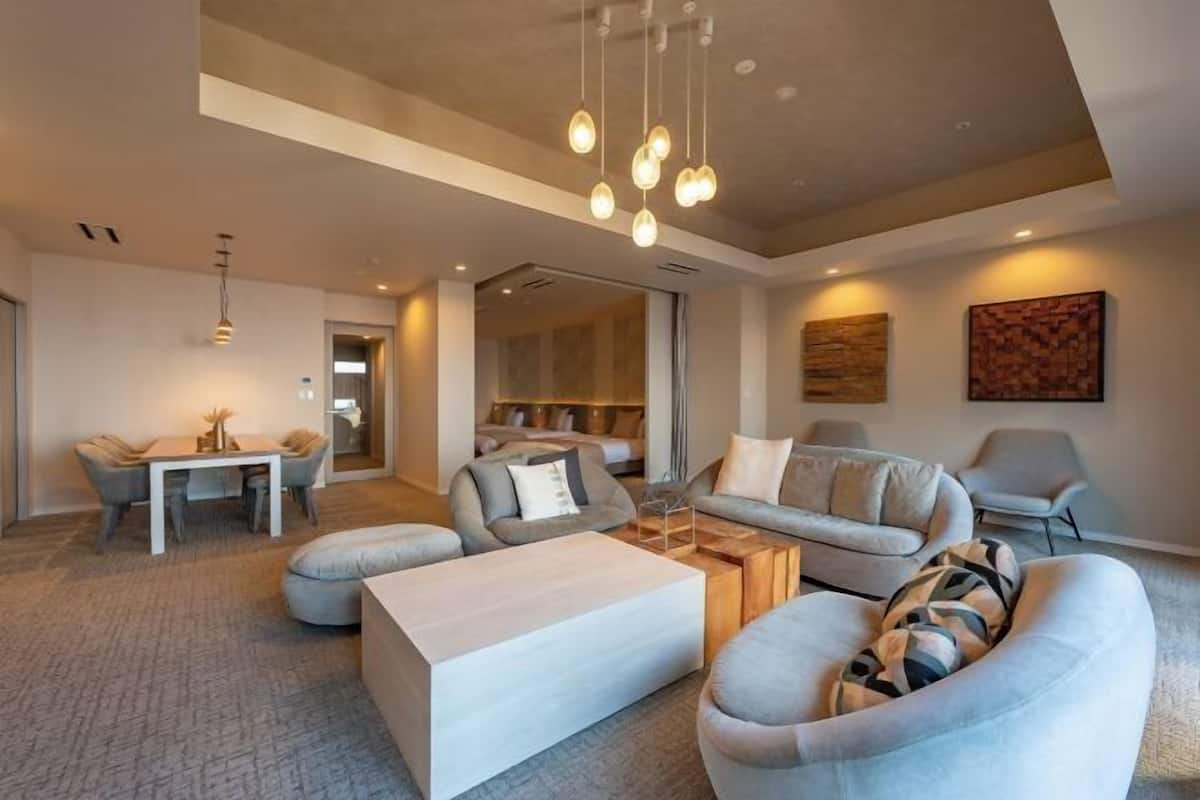 Una sala de estar moderna con un conjunto de sofá, una mesa de centro e iluminación colgante.