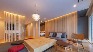 A modern living room with a sofa, a wooden coffee table, and a chair. - Ishinoya Atami (TKP Hotels & Resorts) (Atami)