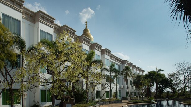 A hotel with a pool, palm trees, and a building with a golden dome. - Gassan Panorama Golf Club (Ban Thi)