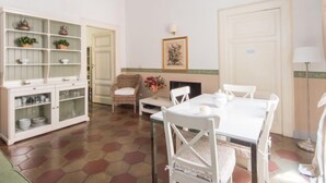 A dining area with a white table, chairs, and a cabinet with glass doors. - Romantico by Interhome (Rome: Historical City Center)