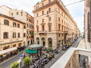 A historic building with a central courtyard, surrounded by parked scooters and cars. - Romantico by Interhome (Rome: Historical City Center)