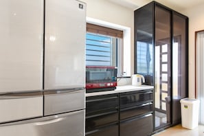 A modern kitchen with stainless steel appliances, a microwave, and a kettle on the counter.