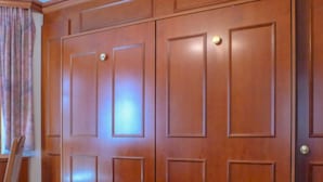 Une porte en bois avec un luminaire placé au-dessus.