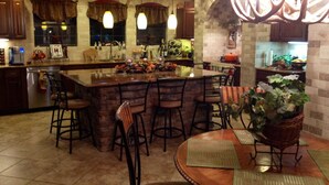 A spacious kitchen with a central island, bar stools, and pendant lighting. - Cody's Happy Trails Ranch Vacation Rental -New Braunfels Texas! (New Braunfels)
