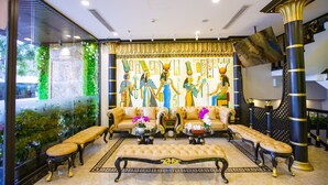 A luxurious lobby with a large wall mural, elegant seating, and a decorative column. - Pharaoh Boutique Hotel Danang (Da Nang)