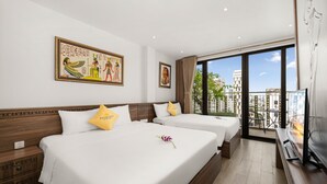 A hotel room with two beds, a large window with a city view, and artwork on the walls. - Pharaoh Boutique Hotel Danang (Da Nang)