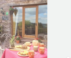 A table set for a meal with a red tablecloth, a pineapple, and various dishes and cups. - Peacock Cottage, Pet Friendly,  Black Mountain Range, nestled on Brecon Beacons (Brecon)