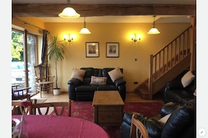 A cozy living room with a sofa set, a coffee table, and a staircase. - Peacock Cottage, Pet Friendly,  Black Mountain Range, nestled on Brecon Beacons (Brecon)