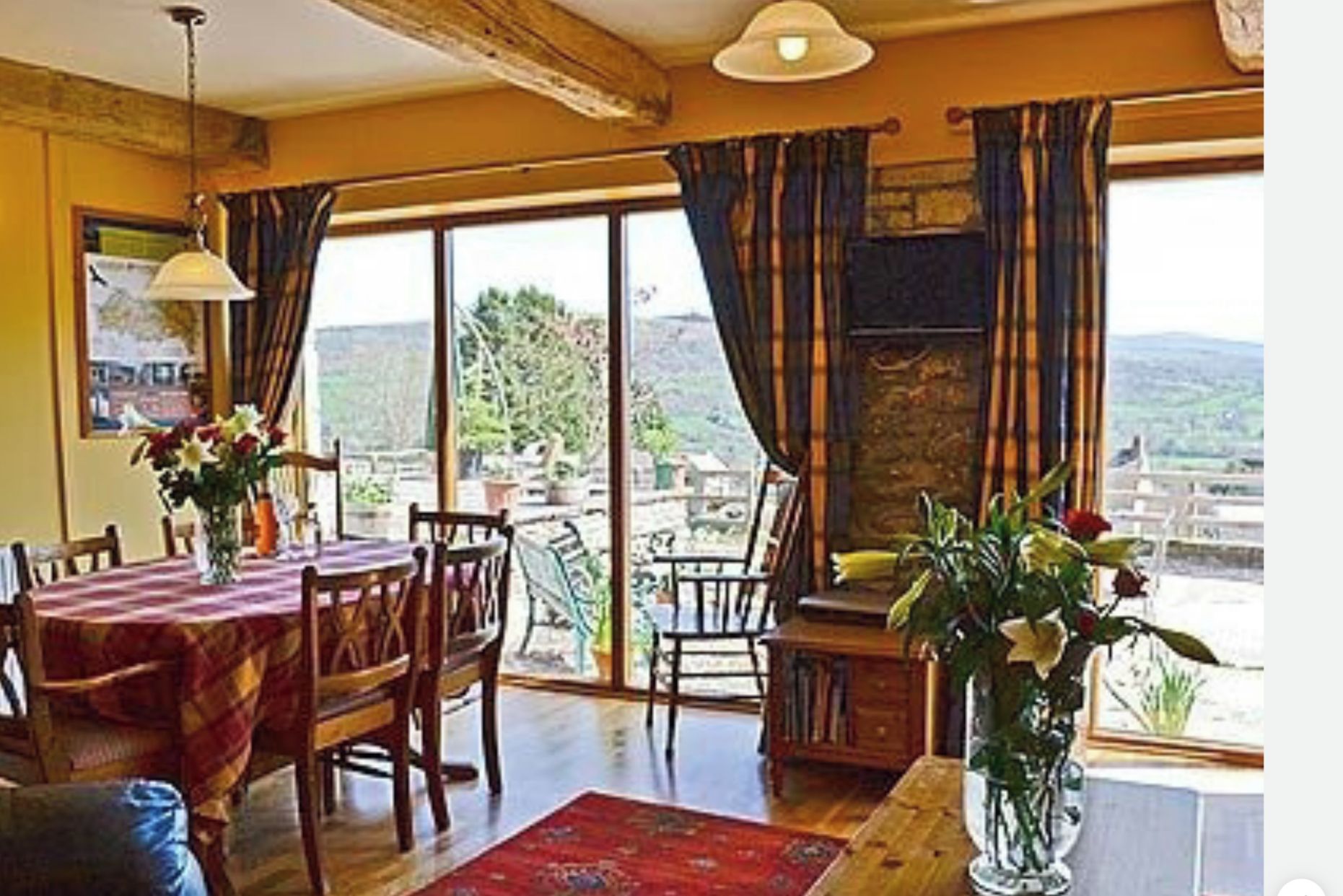 A dining area with a table set for two, a fireplace, and a view of the outdoors.